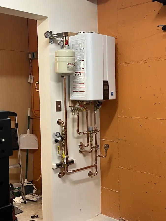 Plumbing technician inspecting water heater connections in DeFuniak Springs